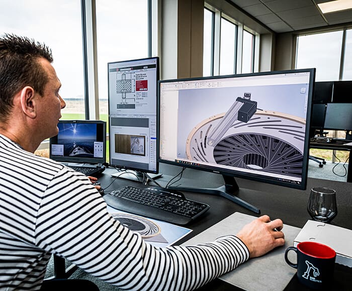 DanRobotics medarbejder arbejder ved sin computer om konstruktionstegning