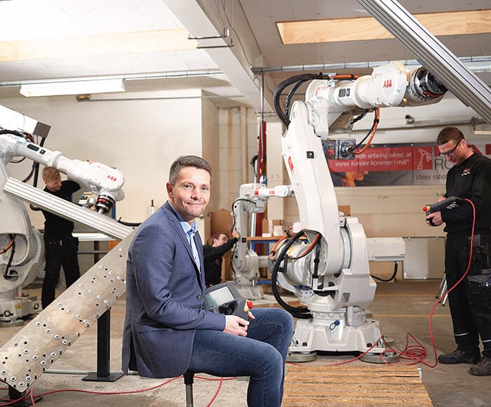 Direktør Kim Koertsen foran to ABB robotter